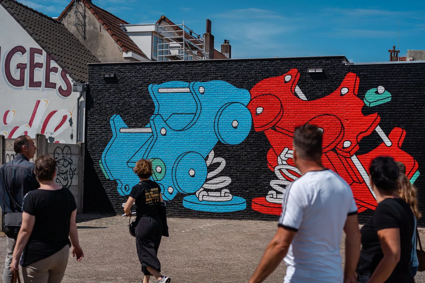 Visitors on a guided tour walking towards a Blind Walls mural in Breda